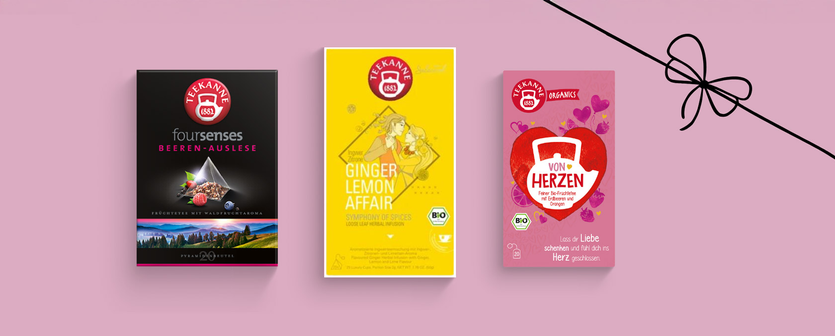 Drei farbenfrohe Teepackungen mit Beeren-, Ingwer-, Zitronen- und Herzmotiven und einem schwarzen Band sind in rosa gehalten.