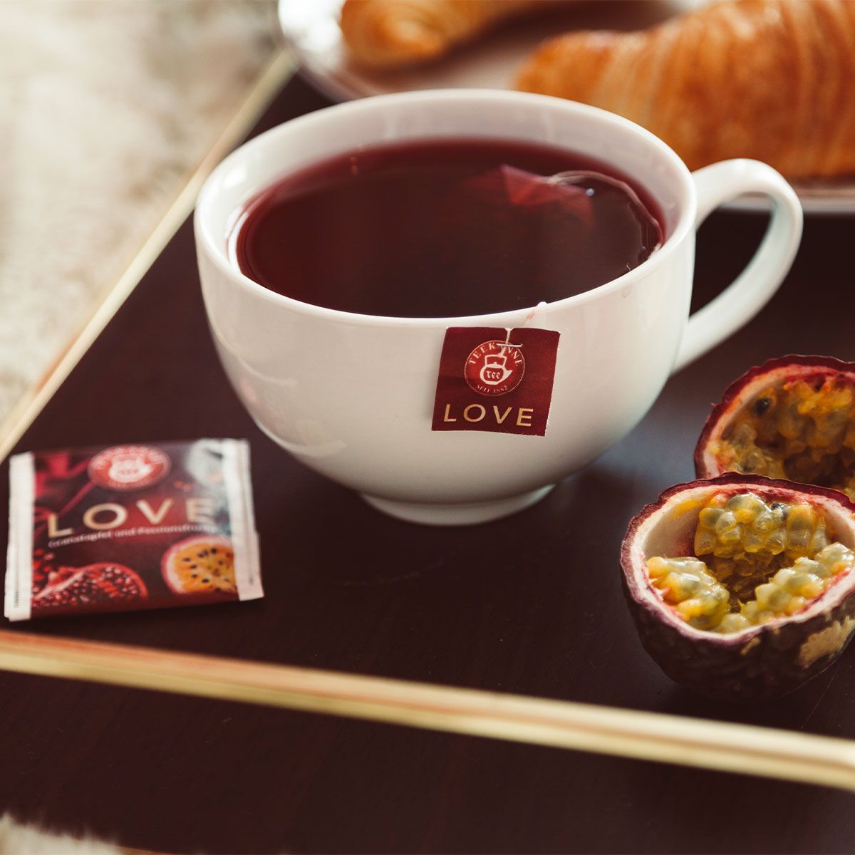 Tasse mit Früchtetee und Maracujafrucht